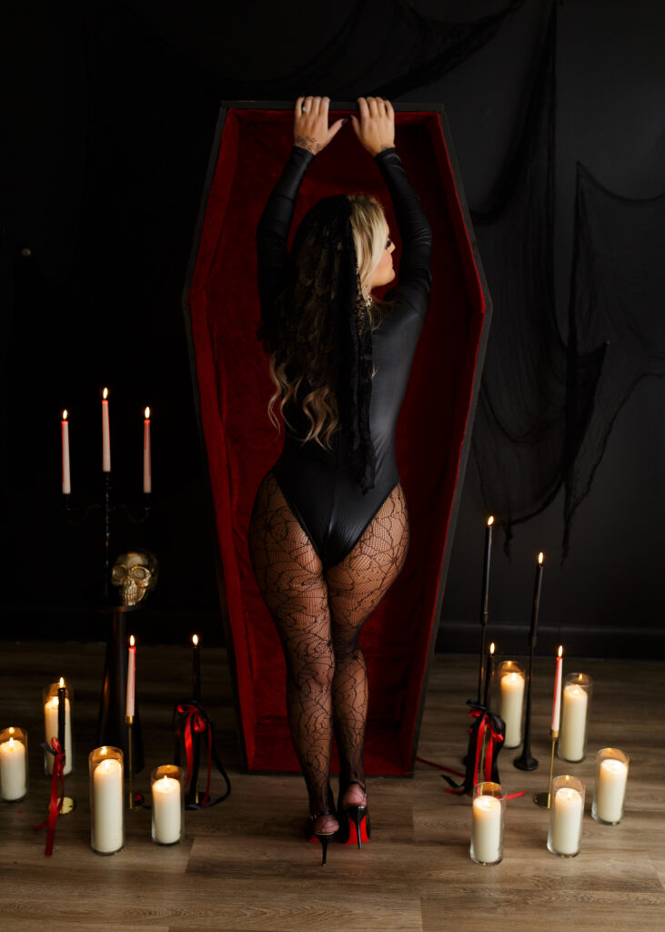 Woman poses with coffin prop for halloween boudoir photoshoot in Richmond Virginia. 