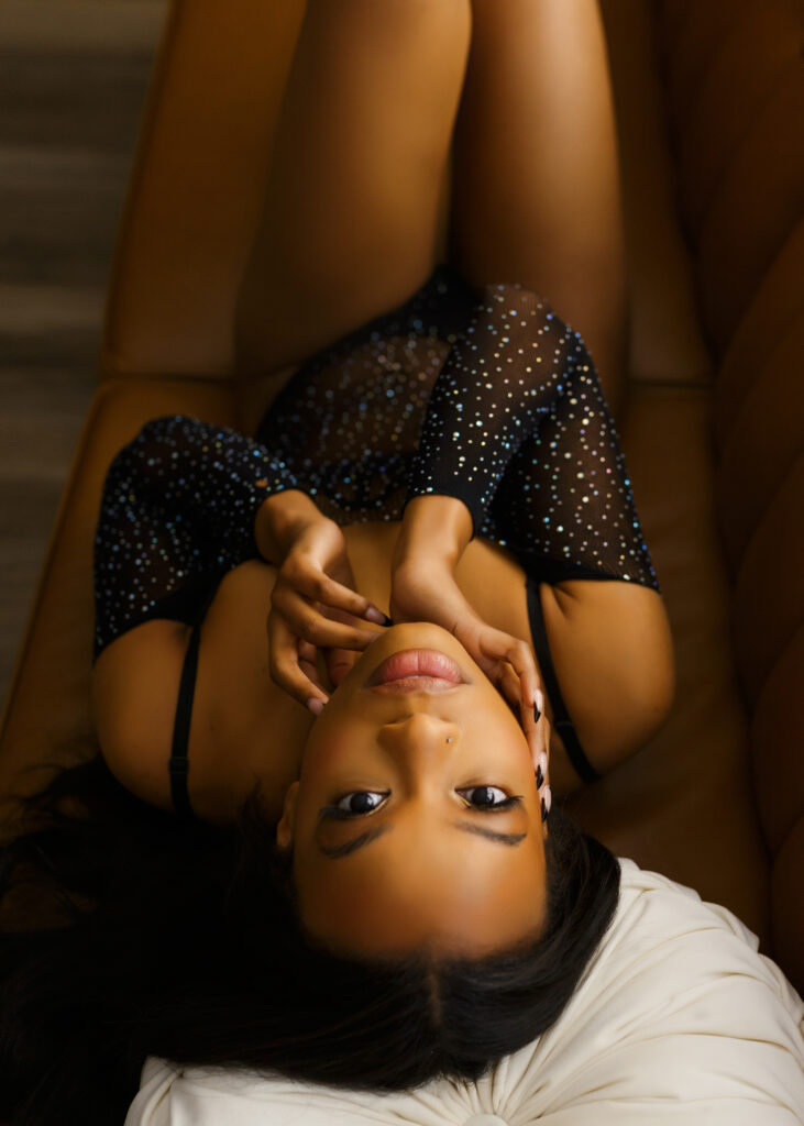 Beautiful black woman posing in sparkling black fishnet lingerie during boudoir photo shoot in Richmond Virginia. 